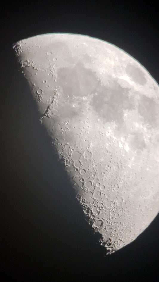 Close-up of the moon's cratered surface photographed through a telescope — telescope filters guide for beginners