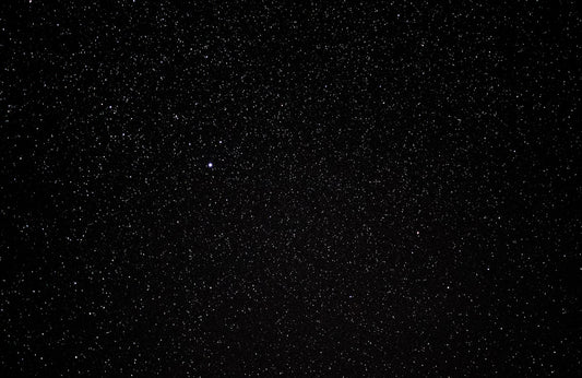 Bright meteor streaking across a dark winter night sky during the Geminid meteor shower