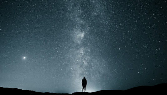 Person using binoculars to observe the night sky — astronomy binoculars vs telescope for beginners